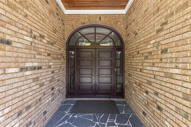 view of exterior entry with brick siding