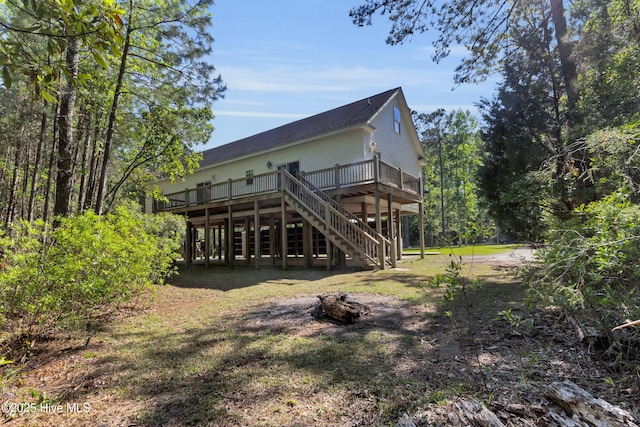 318 Winchester Way, Merritt, NC 28556 - back of property with stairway, a wooden deck, and a fire pit