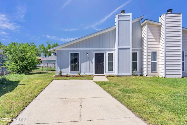 view of front of property featuring a front yard, board and batten siding, and fence