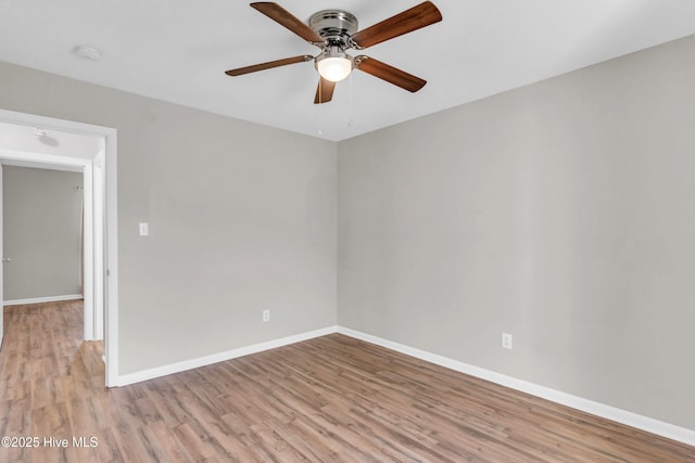 spare room with ceiling fan, wood finished floors, and baseboards