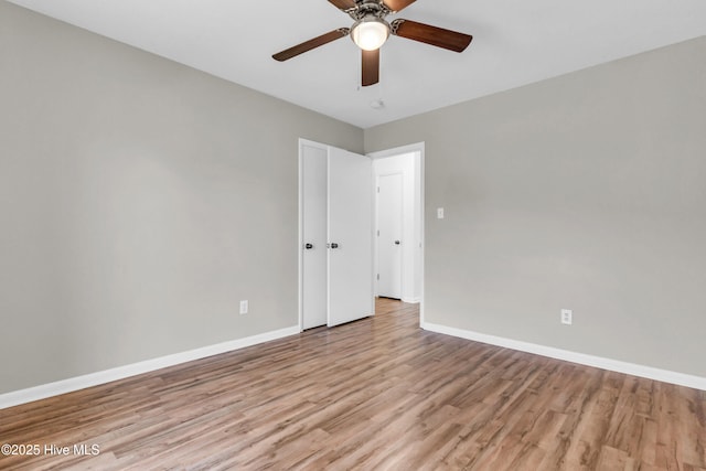 unfurnished room featuring baseboards, light wood-type flooring, and ceiling fan