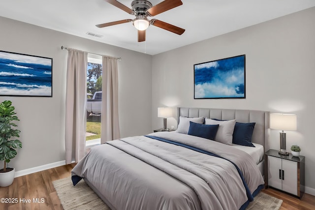 bedroom featuring access to exterior, visible vents, baseboards, and wood finished floors