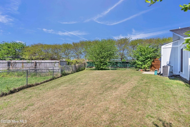 view of yard with a fenced backyard and central AC