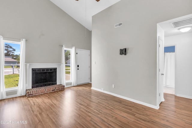 unfurnished living room with visible vents, high vaulted ceiling, wood finished floors, and a ceiling fan
