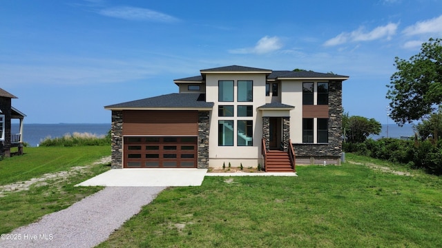 371 Narrow Shore Rd, Aydlett, NC 27916 - view of front facade with stone siding, driveway, stucco siding, a front lawn, and a water view