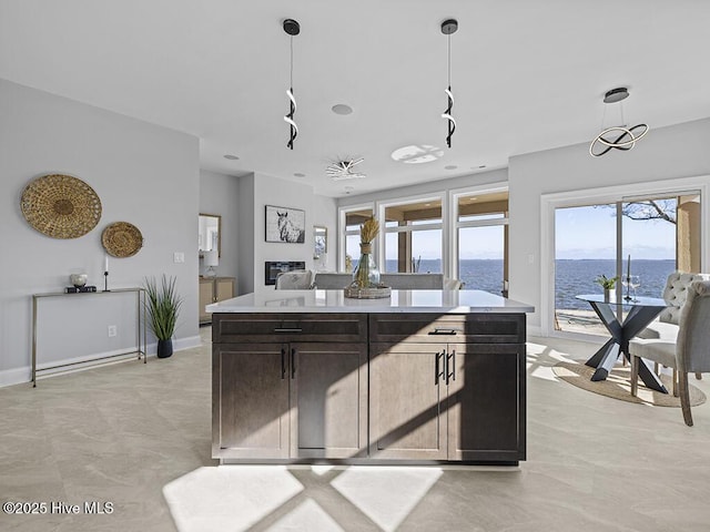 371 Narrow Shore Rd, Aydlett, NC 27916 - kitchen featuring a water view, light countertops, decorative light fixtures, a kitchen island, and baseboards