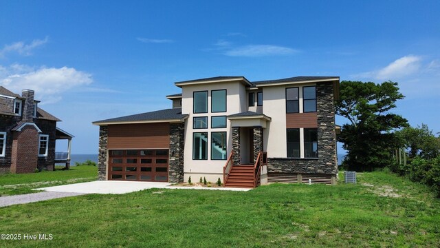 371 Narrow Shore Rd, Aydlett, NC 27916 - contemporary house with stone siding, concrete driveway, stucco siding, a front yard, and an attached garage
