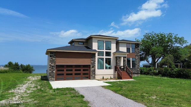 371 Narrow Shore Rd, Aydlett, NC 27916 - view of front of property featuring stone siding, gravel driveway, a front yard, and stucco siding