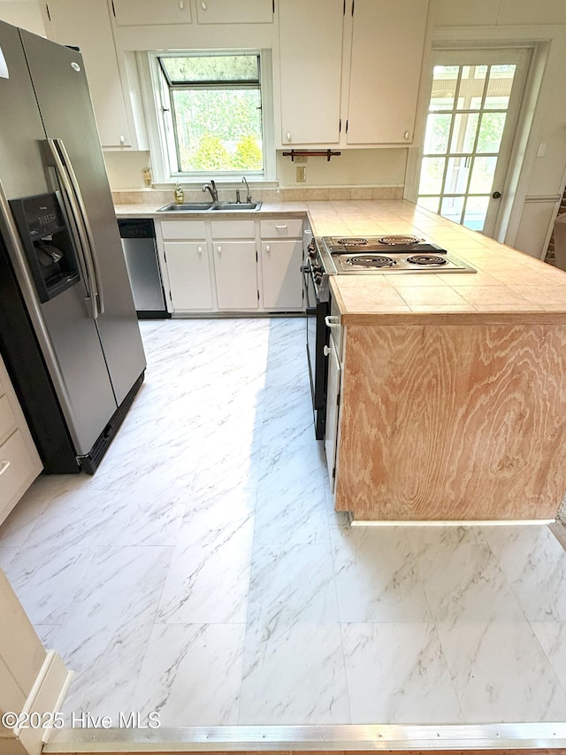 114 Long Leaf Ln, Plymouth, NC 27962 - kitchen featuring a sink, a peninsula, marble finish floor, tile counters, and appliances with stainless steel finishes