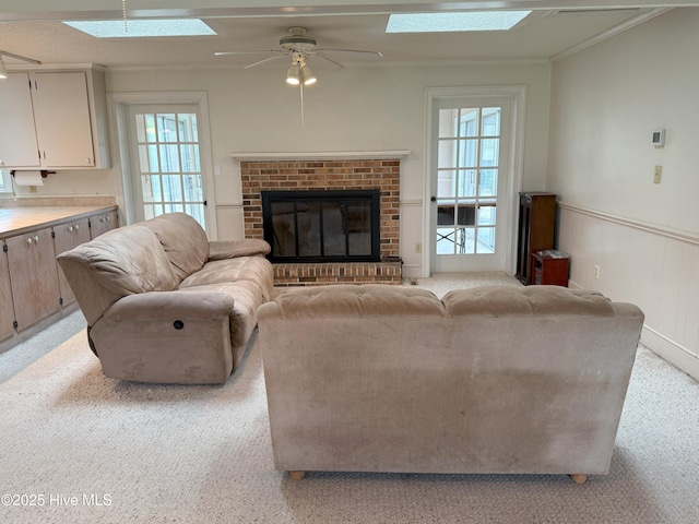 114 Long Leaf Ln, Plymouth, NC 27962 - living area featuring a skylight, crown molding, light carpet, a brick fireplace, and ceiling fan