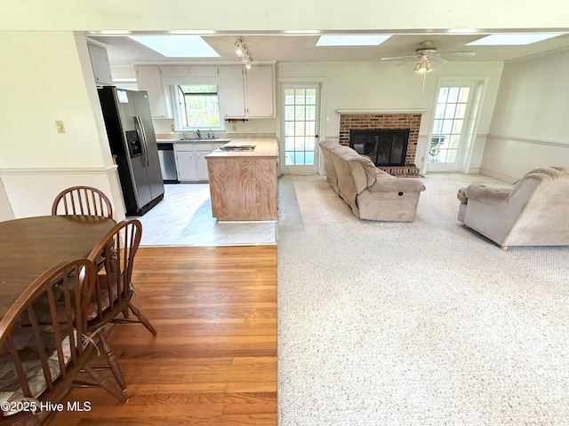 114 Long Leaf Ln, Plymouth, NC 27962 - living room with a fireplace, a skylight, a ceiling fan, and light wood-style floors