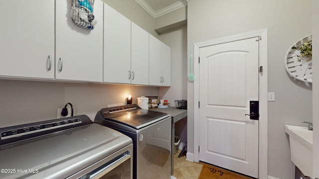 washroom with washing machine and clothes dryer, cabinet space, crown molding, and light tile patterned floors