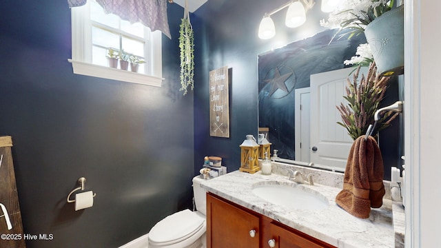 half bathroom featuring toilet and vanity