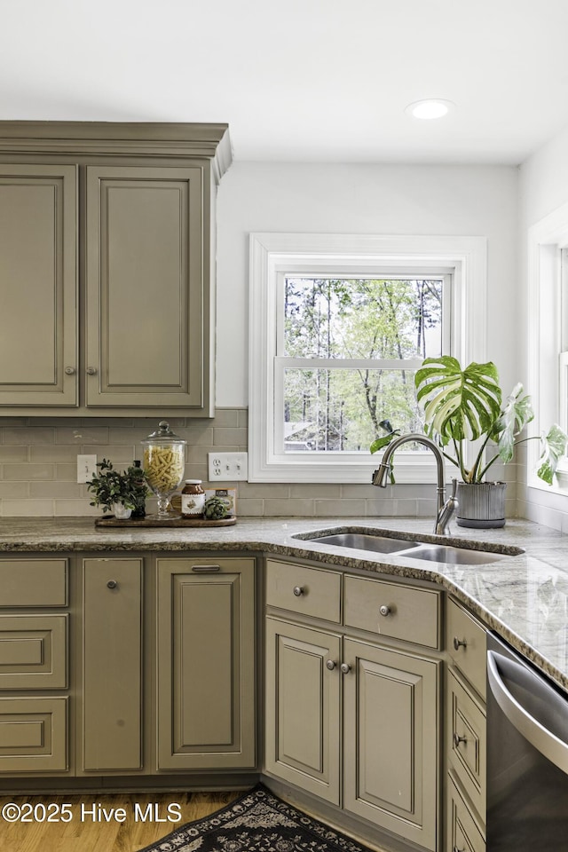 8050 Rachel Wynd Rd NE, Leland, NC 28451 - kitchen with light stone counters, a sink, dishwasher, gray cabinets, and tasteful backsplash