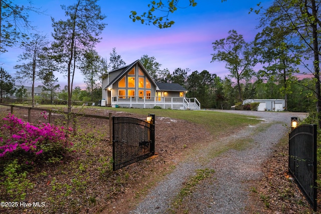 8050 Rachel Wynd Rd NE, Leland, NC 28451 - view of front facade featuring covered porch, driveway, a fenced front yard, a gate, and a garage
