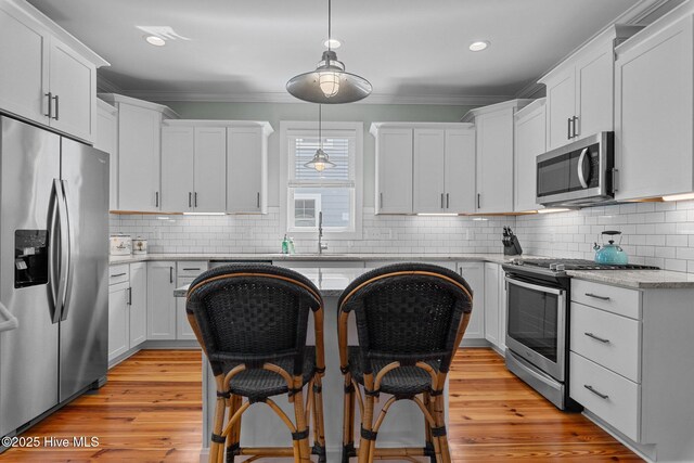 15 Station Ave, Southern Pines, NC 28387 - kitchen featuring crown molding, a sink, backsplash, and stainless steel appliances