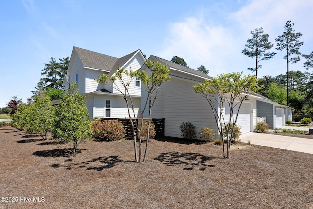 15 Station Ave, Southern Pines, NC 28387 - view of home's exterior featuring a garage, roof with shingles, and concrete driveway