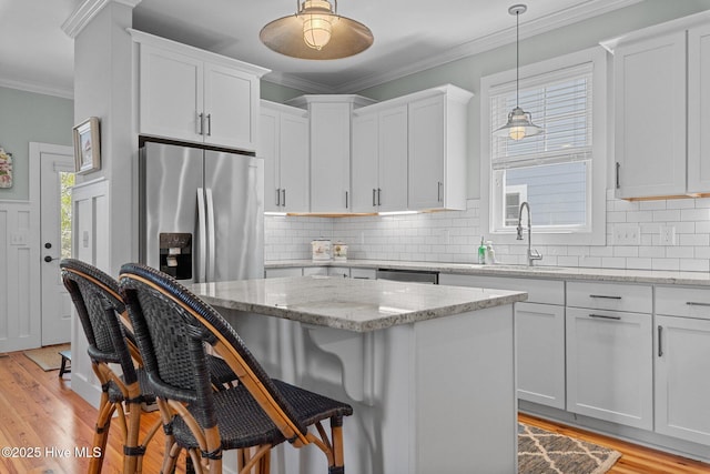 15 Station Ave, Southern Pines, NC 28387 - kitchen with a kitchen bar, light wood-type flooring, white cabinets, appliances with stainless steel finishes, and a sink