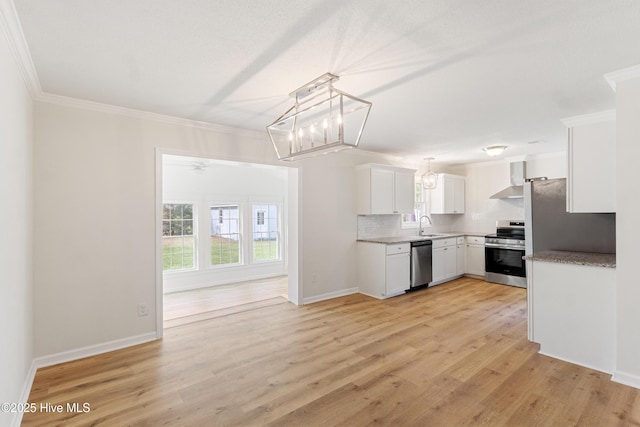 132 Elder Dr, Wilmington, NC 28405 - kitchen featuring stainless steel appliances, healthy amount of natural light, wall chimney exhaust hood, crown molding, and white cabinetry