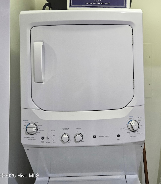 clothes washing area with stacked washer and clothes dryer and laundry area