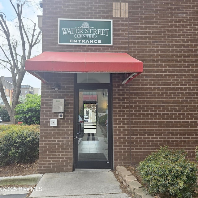 view of exterior entry featuring brick siding