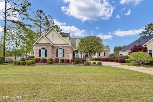 9278 Checkerberry Sq NW, Calabash, NC 28467 - view of front facade featuring brick siding, a front lawn, concrete driveway, and a shingled roof