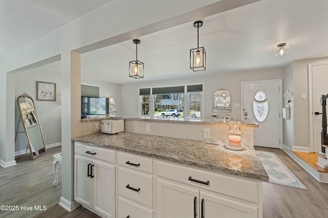722 Christine Ave, Jacksonville, NC 28540 - kitchen featuring hanging light fixtures, white cabinetry, light stone countertops, and light wood-style floors