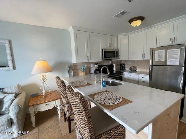 790 New River Inlet Rd Unit 208B, North Topsail Beach, NC 28460 - kitchen featuring stainless steel appliances, a sink, visible vents, white cabinets, and a peninsula