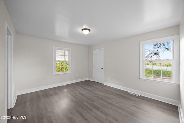 705 W Main St, Conway, NC 27820 - empty room with healthy amount of natural light, dark wood-style flooring, and baseboards