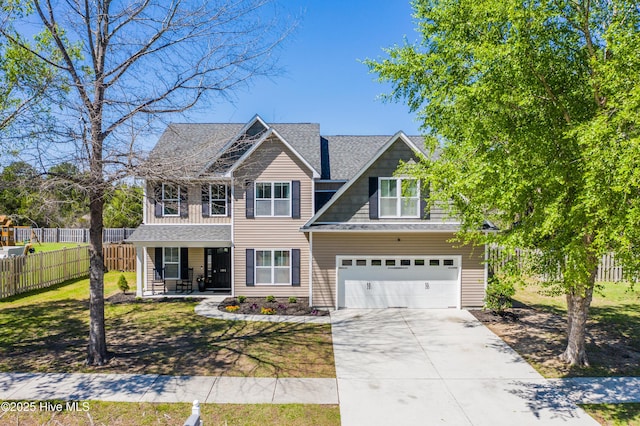 view of front facade with a front yard, covered porch, a garage, fence, and driveway