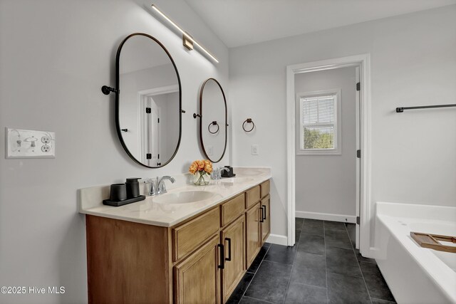 bathroom with a sink, tile patterned floors, double vanity, and a bathtub