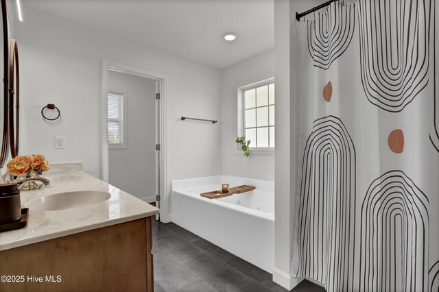 bathroom featuring a sink, a bath, double vanity, and tile patterned flooring