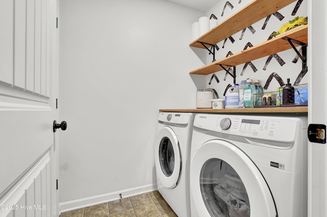 washroom with baseboards, light tile patterned floors, laundry area, and washing machine and clothes dryer
