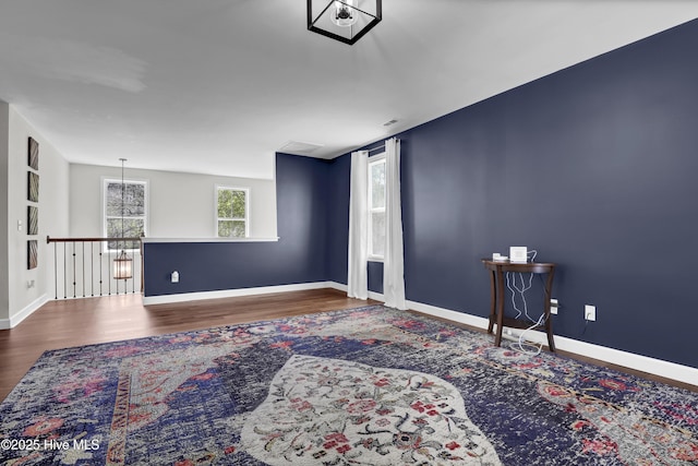 unfurnished room with baseboards and wood finished floors