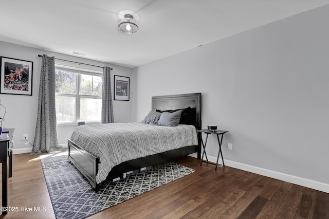 bedroom featuring visible vents, baseboards, and wood finished floors