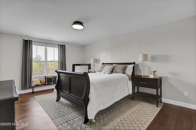 bedroom with baseboards and wood finished floors