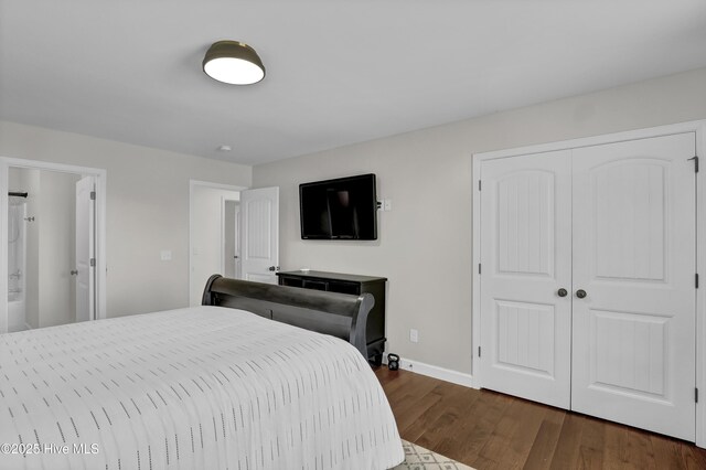 bedroom with a closet, dark wood-style flooring, and baseboards