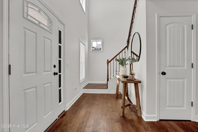 entryway featuring stairway, dark wood-style flooring, and baseboards