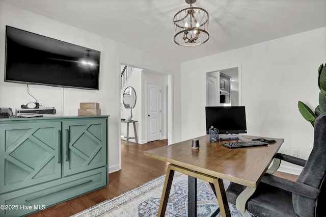office space featuring a notable chandelier, dark wood-style floors, and baseboards