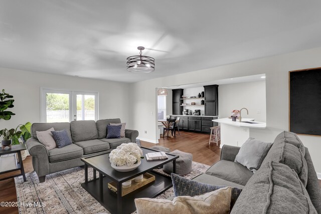 living area with dark wood-type flooring and baseboards