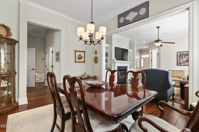 1502 Crows Landing Cir, Wilmington, NC 28403 - dining room with wood finished floors, crown molding, a ceiling fan, a chandelier, and a glass covered fireplace