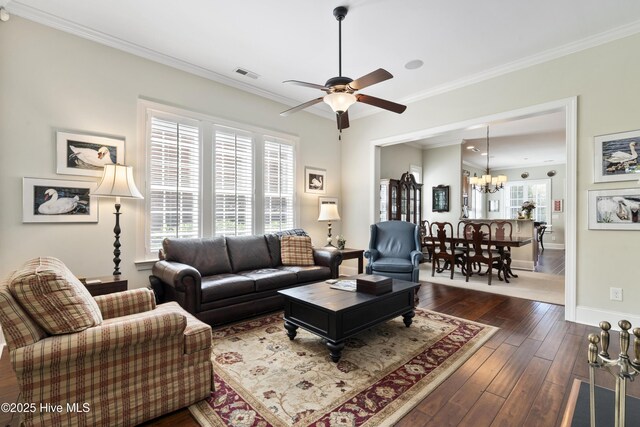 1502 Crows Landing Cir, Wilmington, NC 28403 - living area featuring a chandelier, a ceiling fan, crown molding, baseboards, and dark wood-style flooring