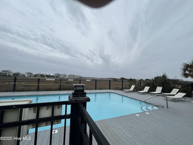 pool with a wooden deck and fence