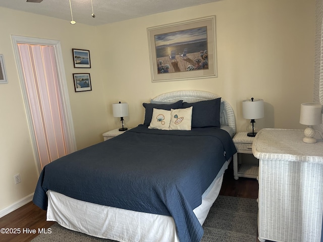 bedroom featuring baseboards and wood finished floors