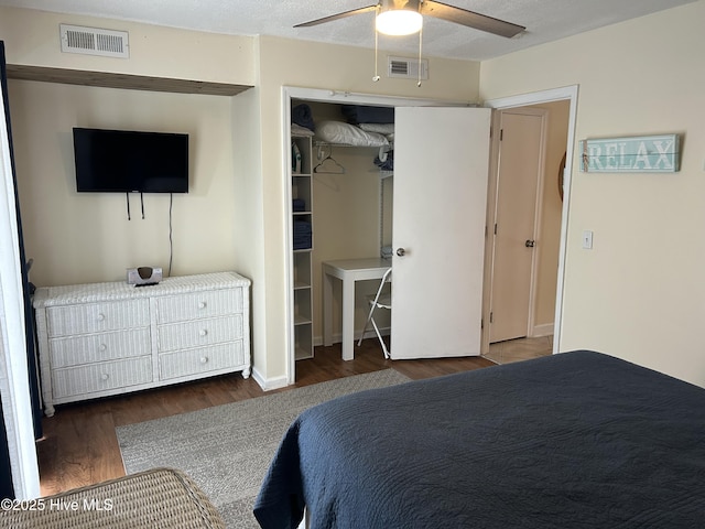 bedroom featuring a ceiling fan, wood finished floors, and visible vents