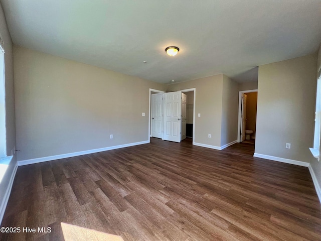 spare room with dark wood finished floors and baseboards