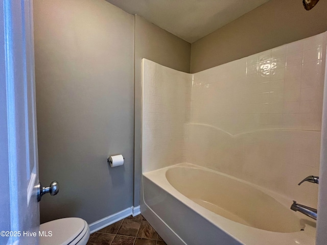 full bathroom with baseboards, toilet, and washtub / shower combination