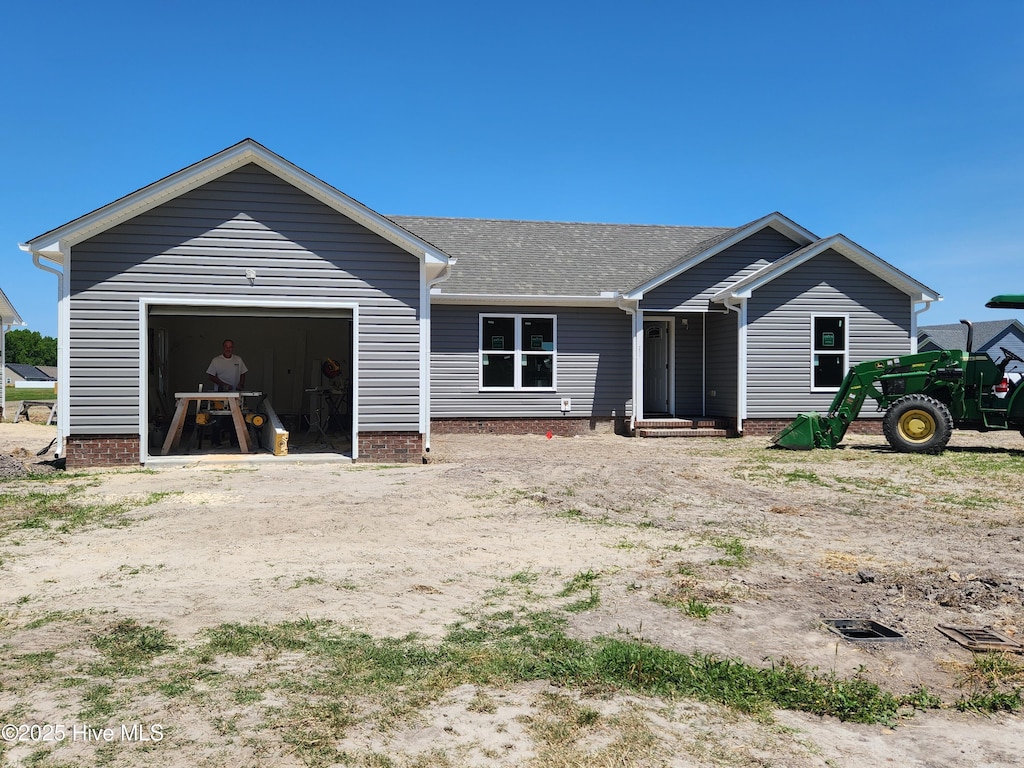 view of front facade featuring a shingled roof and a garage