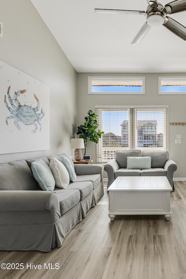 living area with visible vents, ceiling fan, plenty of natural light, and wood finished floors