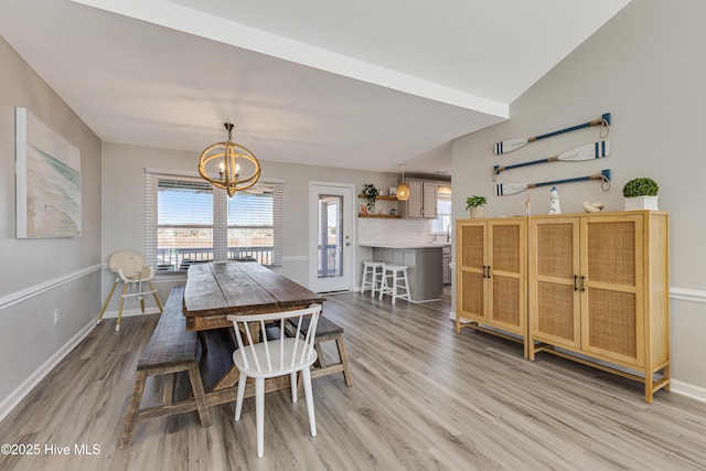 dining space featuring a chandelier, light wood-type flooring, baseboards, and plenty of natural light